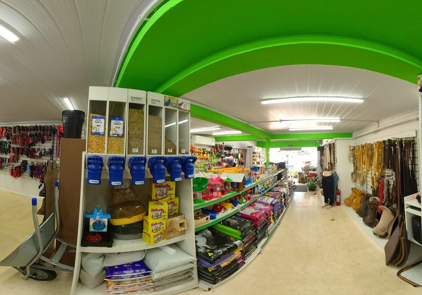 Interior de la tienda con alimento a granel, jaulas, correas y estantes de raciones
